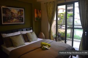 a bedroom with a bed with a stuffed animal on it at Outlook Ridge Residences - North in Baguio