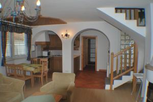 uma cozinha e sala de jantar com uma escada numa casa em Rozália Vendégház em Sarród