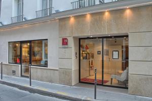 a store with a sign on the side of a building at Résidence du Lion d'Or Louvre in Paris