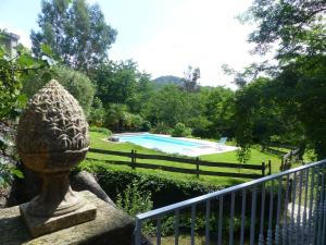 a stone statue on a fence next to a swimming pool at Holiday Home in Ardèche near Château de Ventadour in Fabras +27 photos