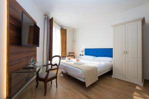 a bedroom with a bed and a desk and a television at TI Central Maria in Maria de la Salut