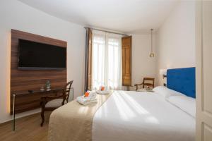 Pokój hotelowy z dużym łóżkiem i biurkiem w obiekcie TI Central Maria w mieście Maria de la Salut +15 zdjęć