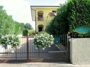 a fence in front of a house with flowers at Belvilla by OYO Argentina Tre in Lazise