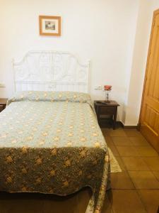 Un dormitorio con una cama con una manta. en Hotel Restaurante Calderon en Arcos de la Frontera