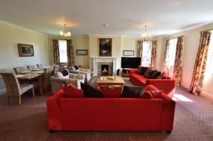 a living room with red couches and a fireplace at Knocklea in Alness
