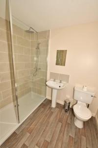 a bathroom with a toilet and a shower and a sink at Knocklea in Alness