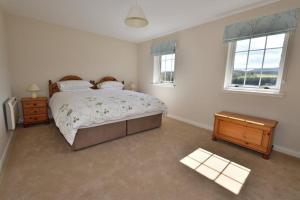 a bedroom with a large bed and a window at Knocklea in Alness