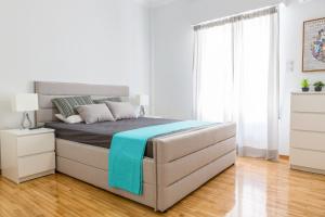 アテネにあるNewly Renovated 100m² Stylish Urban Flatの白いベッドルーム(青い毛布付きのベッド付)