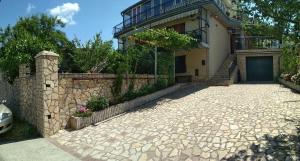 a house with a stone driveway in front of it at Guest House Julia in Senj