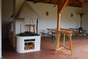 a woodburning stove in a room with tables and tables at Rozália Vendégház in Sarród