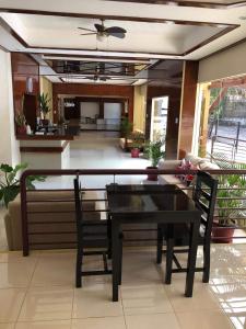 a dining room with a black table and chairs at Hotel Casa Teofista in Panglao