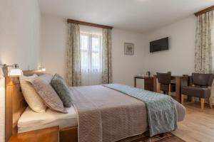 a bedroom with a bed and a table with a chair at Rooms Imperial House in Plitvička Jezera