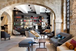 a lobby with couches and chairs in a building at Boutique Hôtel des Remparts & Spa in Aigues-Mortes