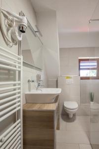a white bathroom with a sink and a toilet at Rooms Imperial House in Plitvička Jezera +36 photos