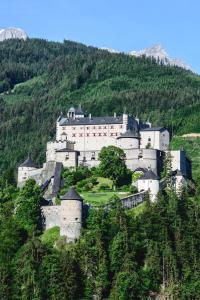 un grand château au sommet d'une colline dans l'établissement Der Burgblick-Adults Only, à Werfen