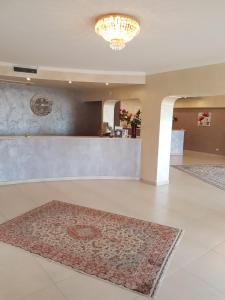 a lobby with a counter and a rug on the floor at Hotel Riviera Palace in Porto Empedocle