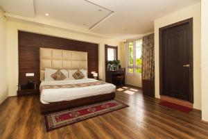 a bedroom with a large bed with a wooden headboard at Jagjeet's Sikkim Retreat in Gangtok