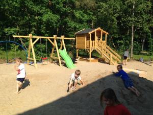 a group of children playing in a playground at Domki Między Sosnami in Pobierowo