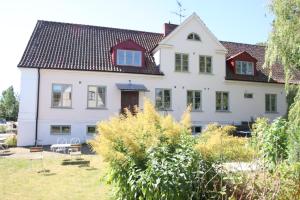 a large white house with a red roof at Mellby 11 Bed & Breakfast in Kivik