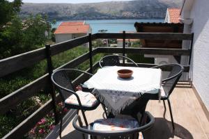 a table and chairs on a balcony with a view at Apartments Jaska in Pag