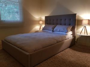 a bedroom with a large bed with two lamps at Myers CBD in Bendigo