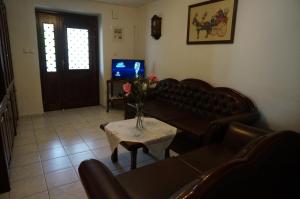 a living room with a couch and a table and a tv at Magnolia in Agios Nikolaos