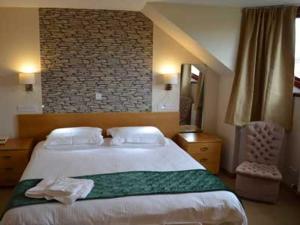 a bedroom with a large bed and a brick wall at Sanderlay Guest House in Kirkwall