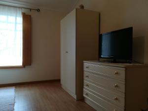 a bedroom with a dresser with a flat screen tv on it at Casa Serra da Lapa in Viseu