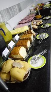 a buffet with many different types of food on plates at Conforto Plaza Hotel in Capitão Leônidas Marques