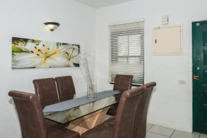 ein Esszimmer mit einem Glastisch und Stühlen in der Unterkunft Santorini - Perissa 3 in Ballito