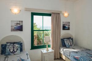 um quarto com uma cama, uma janela, uma cama e uma mesa em Santorini - Perissa 3 em Ballito