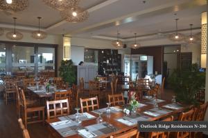 a restaurant with wooden tables and chairs and lights at Outlook Ridge Residences - North in Baguio