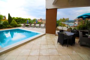 a patio with a swimming pool and tables and chairs at Luxury House on Buzhaka in Sozopol