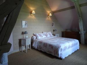 Le Clos des ifs في Thiétreville: غرفة نوم مع سرير كبير و منضدة مع سيد السرير