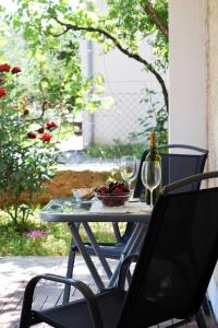- une table avec 2 verres à vin et un bol de fruits dans l'établissement Apartman Klarin, à Zadar