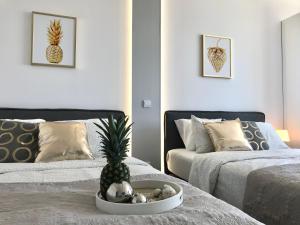 sypialnia z 2 łóżkami i ananasem na stole w obiekcie Exclusive Apartments Smolna w Warszawie
