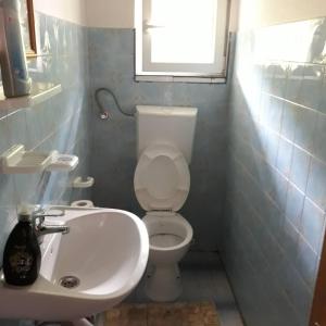 een badkamer met een wit toilet en een wastafel bij HM - konak in Srebrenica