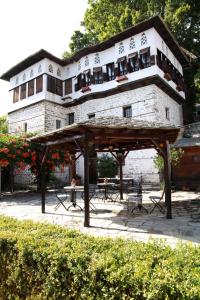 a large building with tables and chairs in front of it at Archontiko Blana in Vizitsa