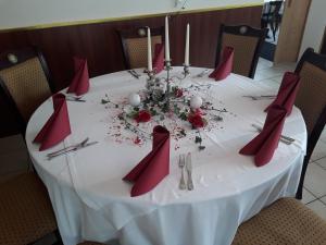 une table blanche avec des serviettes rouges et des fleurs sur elle dans l'établissement Mühlwinkler Hof, à Bergen