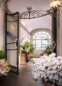 una entrada a un edificio con una puerta y flores en Hotel Torre Guelfa Palazzo Acciaiuoli en Florencia