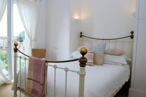 a bedroom with a bed with pink and white pillows at Onefifty in Cowes