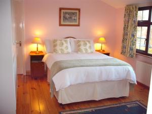 a bedroom with a large bed with two lamps at Maryville Bed and Breakfast in Nenagh