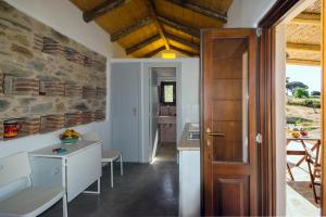 une cuisine et une salle à manger avec un mur en pierre dans l'établissement The pigeon House, à Potamós