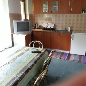 a room with a kitchen with a table and a tv at HM - konak in Srebrenica +2 photos