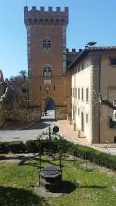 a large brick building with a gate in front of it at Torre rossa in Bolgheri