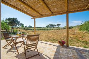 a patio with a table and chairs and a view of a field at The pigeon House in Potamós