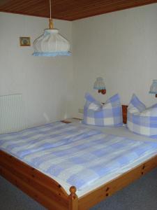 a bed with blue and white pillows in a room at Brandstättgut in Altenmarkt im Pongau