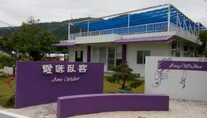 a house with a purple sign in front of it at Amy Walker B&B in Taimali