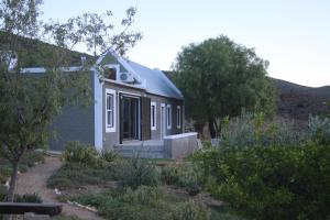 a small house in the middle of a garden at Matjiesvlei Cottages in Calitzdorp