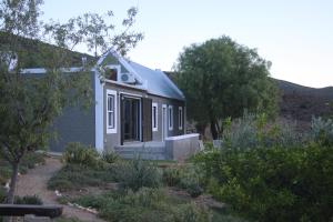 
a white house with a large window at Matjiesvlei Cottages in Calitzdorp
